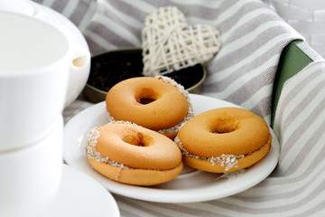 Two cups of hot tea with delicious cookies on  wooden table.