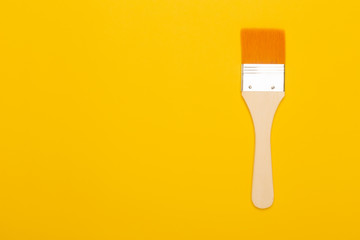 Paint brush isolated on yellow background with copyspace.