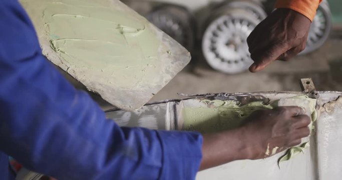 African man painting a car