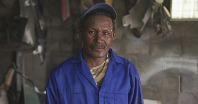 Old African handyman looking at camera