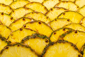 Pineapple juicy yellow slices background. Top view.