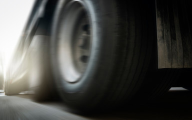 Speed motion blur of a truck trailer, closeup a truck wheels