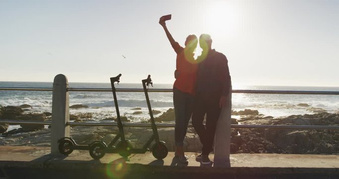 Senior couple taking picture alongside beach