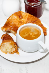 cup of espresso and fresh croissants on white background, top view