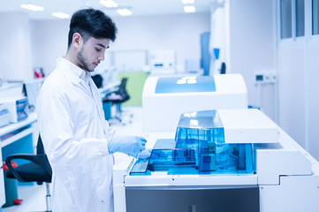 Portrait scientist man using and standing with automatic machine in laboratory.Researcher analysis blood chemistry in medical laboratory. Medical healthcare technology research concept.