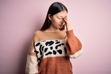 Young beautiful asian woman wearing animal print fashion sweater over pink isolated background tired rubbing nose and eyes feeling fatigue and headache. Stress and frustration concept.