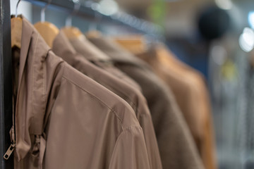 Pastel clothing shirts hang on hangers in a shop background. A variety of clothes  hanging in the wardrobe.