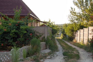 Fototapeta na wymiar Village lane with beautiful landscape house and road
