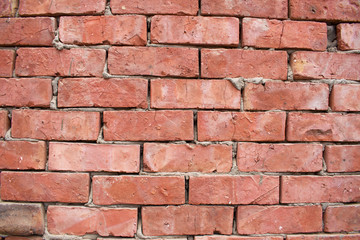 Brick wall made from light red bricks. Background of red brick wall close up.