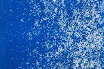 Fototapeta na wymiar Texture of small snowflakes on a blue surface