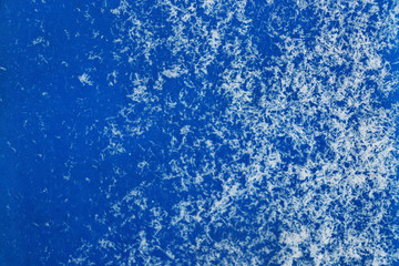 Texture of small snowflakes on a blue surface