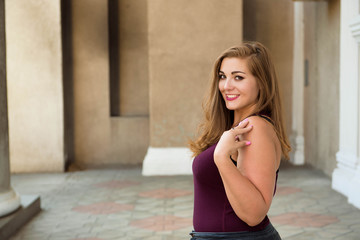 Beautiful overweight woman posing on city street.