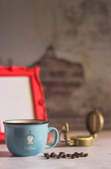 Black coffee in Blue cup on freshly roasted coffee beans background. Top view.