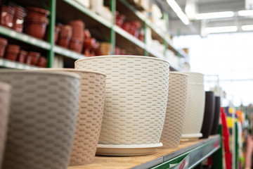 plastic flower pots, pots for indoor plants, garden tools store, shelves with flower pots