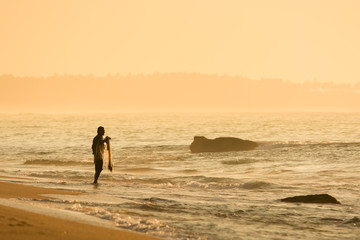 Fototapeta na wymiar Fisherman on the sandy beach during sunrise, Sri lanka, Tangalle, Asia