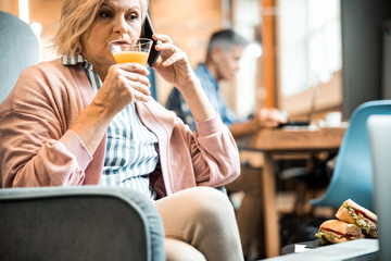 Beautiful mature female holding glass of juice