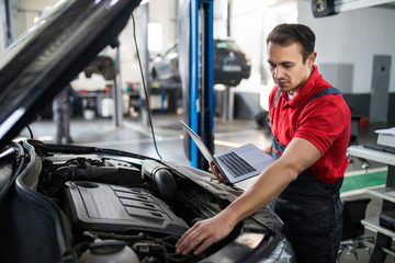 Professional man car mechanic working in auto repair service.
