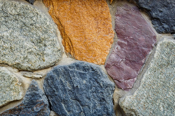 stone background from granite stones of different colors antique, for advertising in the construction industry