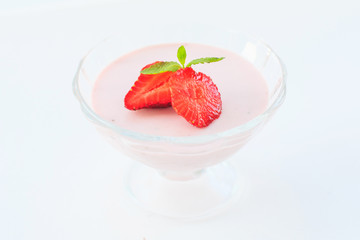 delicate strawberry ice cream with slices of strawberries with cream in a glass bowl on a light background, for advertising confectioners or sweets