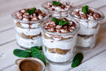Tiramisu cake in glass, classic Italian dessert with mascarpone cream and cocoa. selective focus.