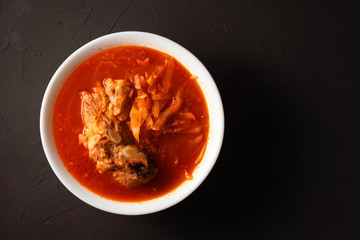 borsch in a white plate on a dark table