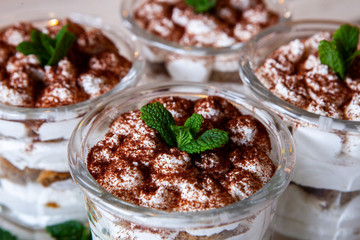 Tiramisu cake in glass, classic Italian dessert with mascarpone cream and cocoa. selective focus.