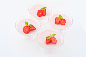 delicate strawberry ice cream with slices of strawberries with cream in a glass bowl on a light background, for advertising confectioners or sweets