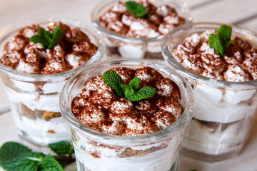 Tiramisu cake in glass, classic Italian dessert with mascarpone cream and cocoa. selective focus.