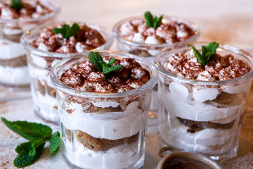 Tiramisu cake in glass, classic Italian dessert with mascarpone cream and cocoa. selective focus.