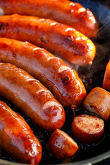 Fried pork sausages on a black background, close up view