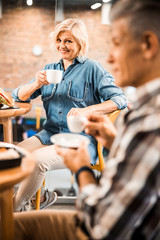 Happy adult man and lady holding cups with hot drink