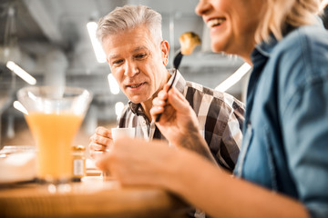 Smiling mature couple is enjoying lunch together