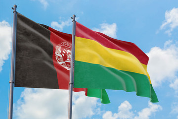 Bolivia and Afghanistan flags waving in the wind against white cloudy blue sky together. Diplomacy concept, international relations.