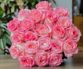 bouquet with delicate fragrant rose flowers on a wooden background, a gift for the holiday