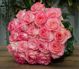 bouquet with delicate fragrant rose flowers on a wooden background, a gift for the holiday