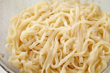 Boiled udon noodle in colander 