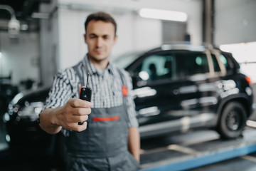 Mechanic handling keys of a car at the service garage