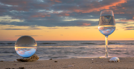Reflet dans un verre et une boule de cristal au coucher du soleil.