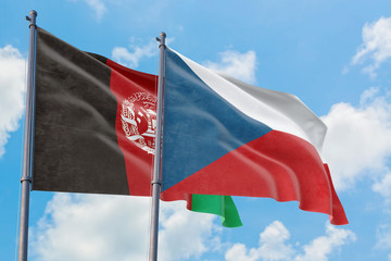 Czech Republic and Afghanistan flags waving in the wind against white cloudy blue sky together. Diplomacy concept, international relations.