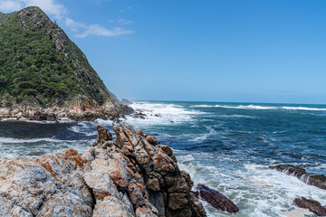 Felsküste mit Felsen im Vordergrund Meeresbrandung und blauem Himmel in Südafrika