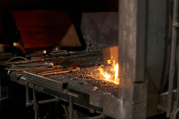 forge furnace with burning flame and blacksmith tools