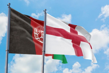 England and Afghanistan flags waving in the wind against white cloudy blue sky together. Diplomacy concept, international relations.