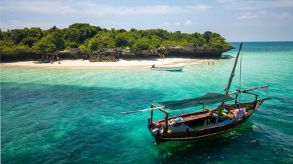 Fototapeta na wymiar Beautiful exotic island with a private beach and a boat docked in Zanzibar Tanzania
