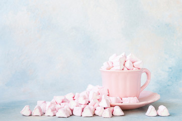 Pinc Heart Shape marshmallows in a pink cup on a sky blue background