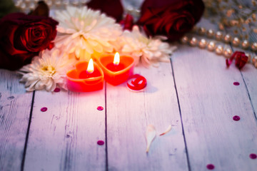 two red burning burning candles hearts flowers bow close up pearls