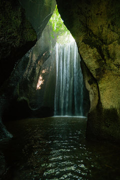 Beautiful secret Tukad Cepung Waterfall, Tembuku, in canyon. Under the ray of light in the cave in Bali, Indonesia