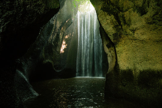 Beautiful secret Tukad Cepung Waterfall, Tembuku, in canyon. Under the ray of light in the cave in Bali, Indonesia