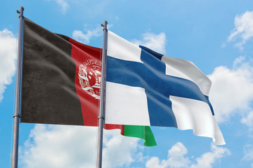 Finland and Afghanistan flags waving in the wind against white cloudy blue sky together. Diplomacy concept, international relations.