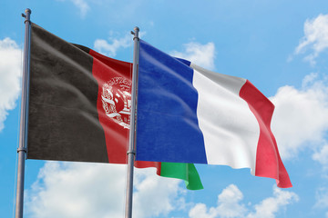 France and Afghanistan flags waving in the wind against white cloudy blue sky together. Diplomacy concept, international relations.
