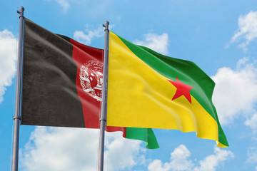 French Guiana and Afghanistan flags waving in the wind against white cloudy blue sky together. Diplomacy concept, international relations.